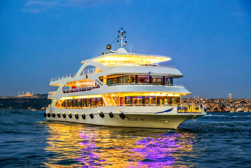 AMOR dinner cruise boat lit up on the Bosphorus at blue hour, Istanbul