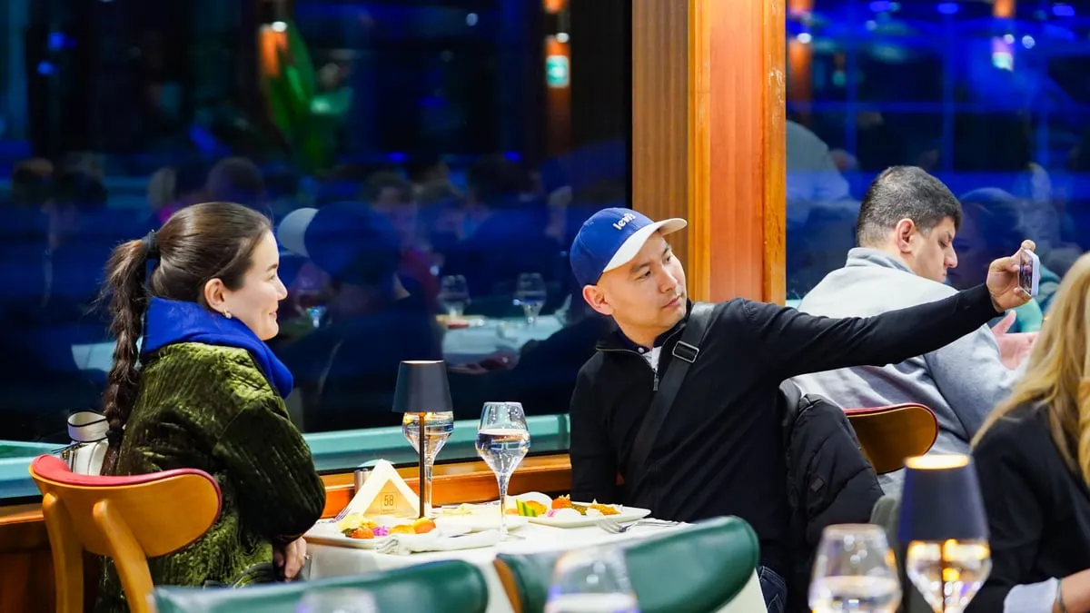 Couple taking a selfie at their window table on the AMOR Bosphorus dinner cruise