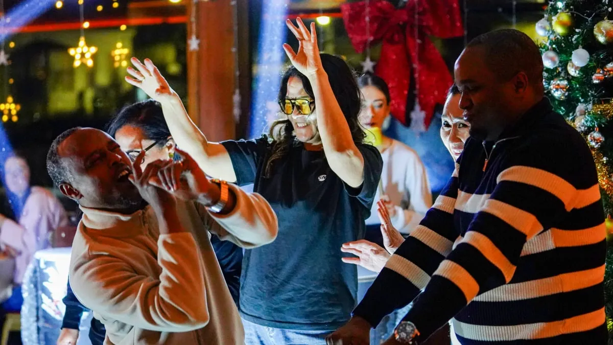 Guests dancing with hands in the air during the DJ set on the AMOR dinner cruise