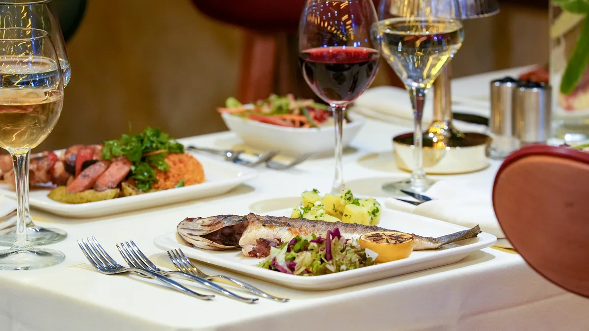 Grilled fish main course on a set table aboard the AMOR