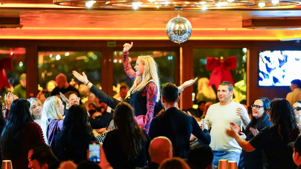 Guests raising their hands under the mirror ball on the AMOR Bosphorus cruise
