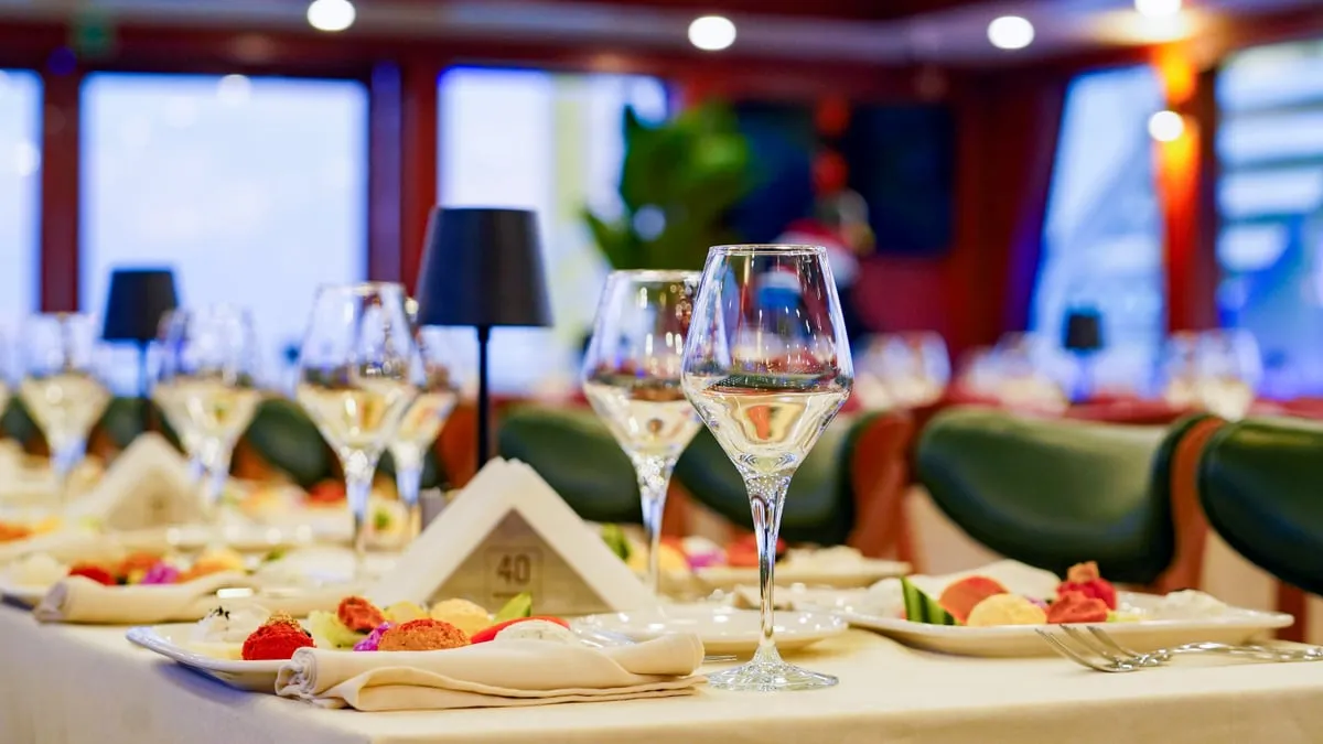 Laid dinner tables with wine glasses in the AMOR panoramic salon