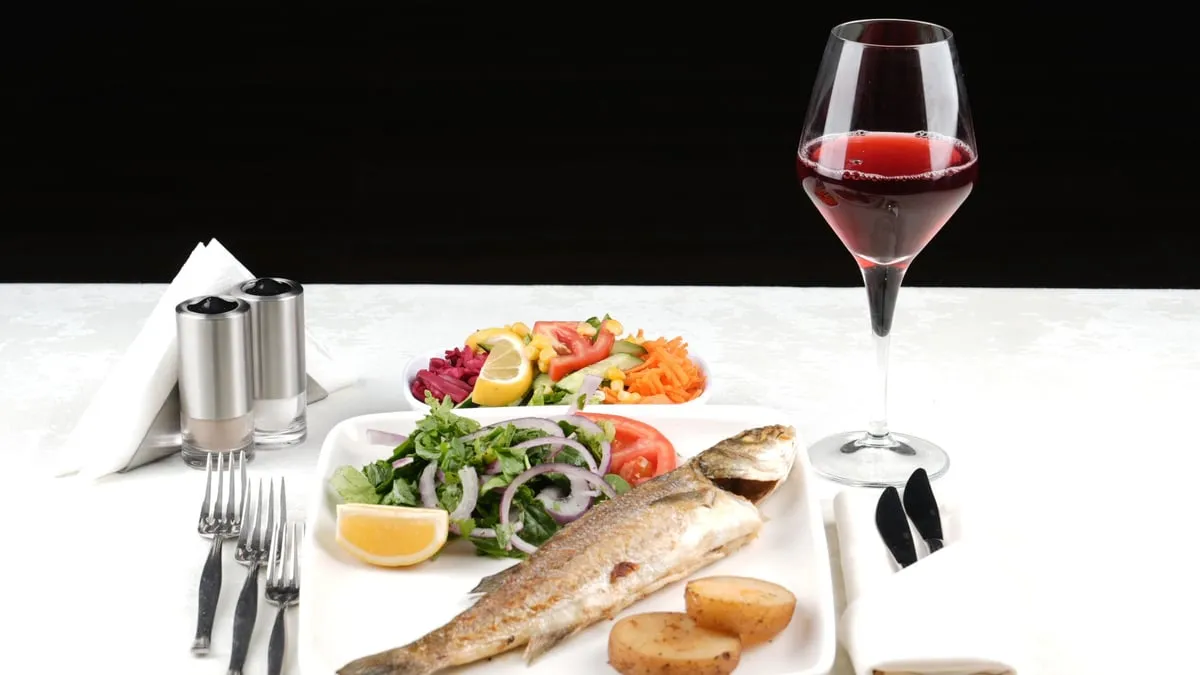 Grilled sea bass main course with seasonal salad and red wine on the AMOR Bosphorus dinner cruise