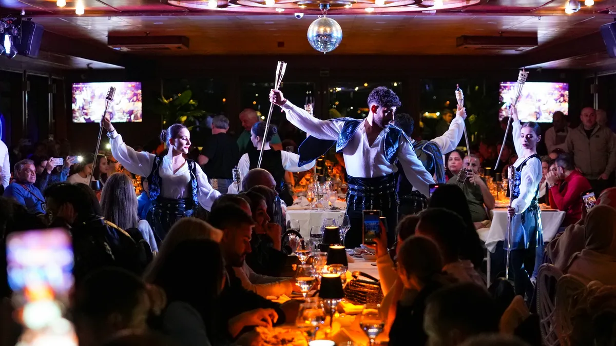 Caucasian dancers performing with torches among the dinner tables on board